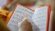 Close-up of a person reading an Arabic text, highlighting cultural education and learning.