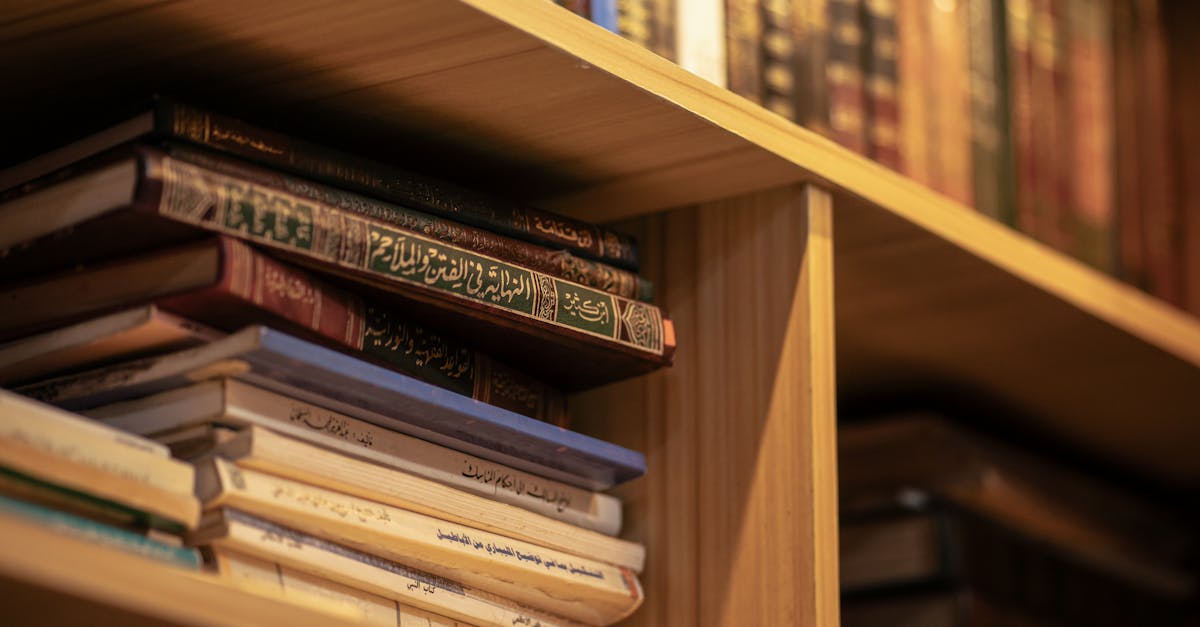 A stack of Islamic religious books on a wooden shelf, highlighting Arabic scripts and cultural significance.